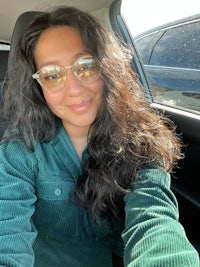 a woman wearing sunglasses in the back seat of a car